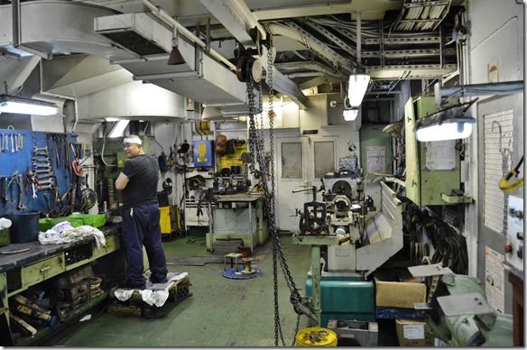 a1510 die Werkstatt mit einem Mech. der gerade ein Wellenende einschleift